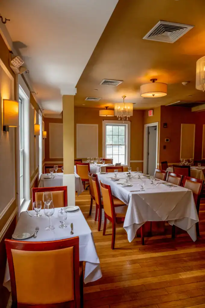 Luxurious interior of Tartufo with warm lighting, framed walls, and sophisticated dining setup.